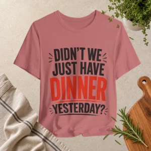 Mauve T-shirt featuring bold black and red typography reading “Didn’t We Just Have Dinner Yesterday?”